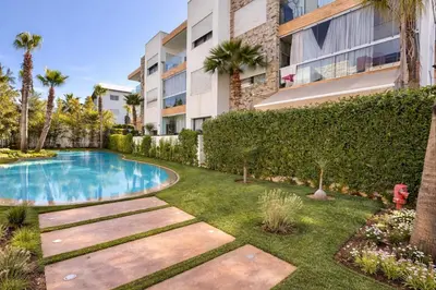 a garden with a swimming pool and a building at Luxury 2Ch Face Plage 3 Piscines Jardin in Tamaris