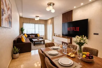 a living room with a television and a dining table at Luxury 2Ch Face Plage 3 Piscines Jardin in Tamaris