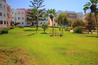a park with trees and flowers in the grass at Mohammedia Appartement in Mohammedia