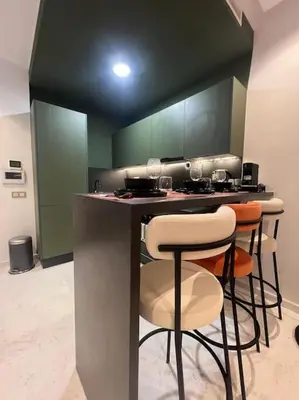 a kitchen with a bar with stools in it at Luxury Residence So Stylish & Bright Appartement Hotel Au Coeur de Casablanca prés de Carrefour et 3 Min de La Gare Ferroviere Oasis in Casablanca