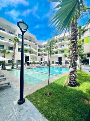 a pool with a palm tree next to a building at Appartement Dahlia - Haut Standing - Mohammedia Natura Living in Mohammedia