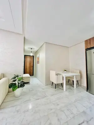 a living room with a table and chairs at Appartement Dahlia - Haut Standing - Mohammedia Natura Living in Mohammedia