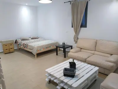 a living room with a couch and a bed at Sweet Home in Maarif