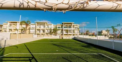 a tennis court in front of a apartment building at Cosy Apartment with sea view in Sidi Rahal