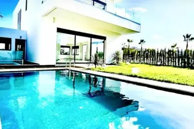 a swimming pool in front of a house at Poolside Paradise Villa in Dar Ben Abdallah Ben Dehbi