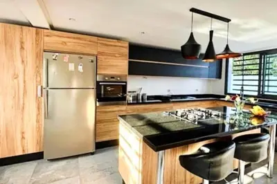 a kitchen with a stainless steel refrigerator and black counter tops at Poolside Paradise Villa in Dar Ben Abdallah Ben Dehbi
