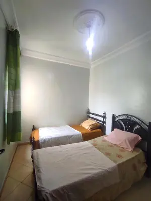 a bedroom with two beds and a light on the wall at Appartement familial calme 3 min à Casanearshore in Casablanca