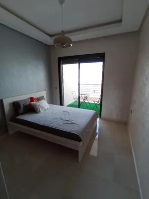 a bedroom with a bed and a large window at Magnifique appart vue piscine 5min de la plage in Kasba Bou Hamira