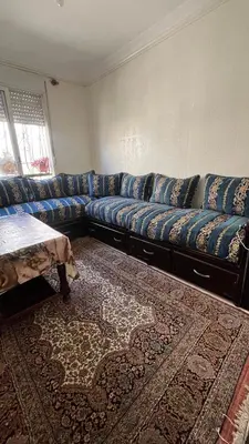 a blue couch in a living room with a rug at Appart meublé 5min de la plage à Bouznika in Bouznika