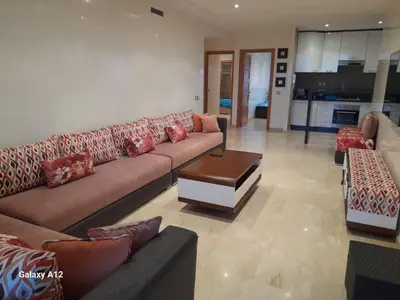 a large living room with a couch and a table at Evasion bouznika in Sidi el Haj Bou Derbala