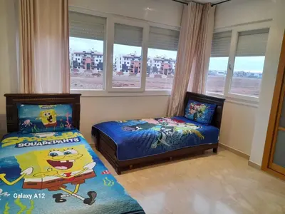 a bedroom with two beds and a window at Evasion bouznika in Sidi el Haj Bou Derbala