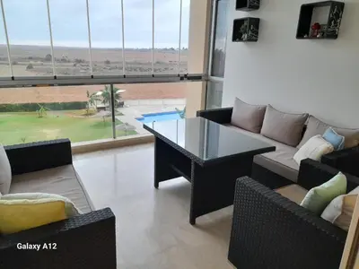 a living room with a couch and a table at Evasion bouznika in Sidi el Haj Bou Derbala