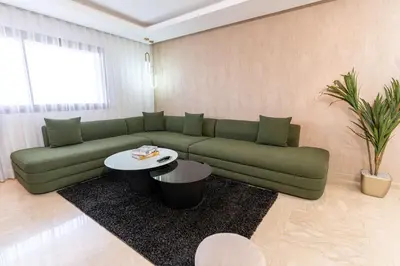 a living room with a green couch and a table at Penthouse View 2BR Terrace - AppartAli Luxury Platform in Casablanca