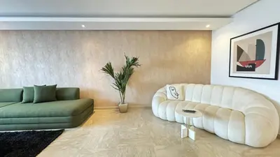 a living room with a white couch and a green sofa at Penthouse View 2BR Terrace - AppartAli Luxury Platform in Casablanca