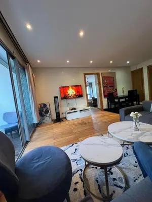 a living room with couches and tables and a tv at Luxueux Studio à La marina in LʼOasis