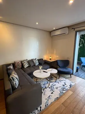 a living room with a couch and a table at Luxueux Studio à La marina in LʼOasis
