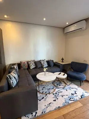 a living room with a couch and a table at Luxueux Studio à La marina in LʼOasis