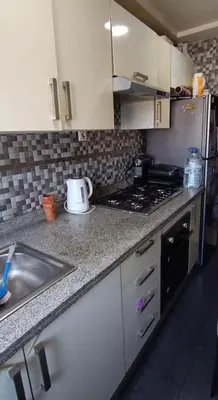 a kitchen with a sink and a stove top oven at الشقة دار بوعزة in Dar Bouazza