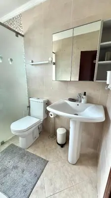 a bathroom with a sink and a toilet and a mirror at T1 App moderne 2 chambres, a 10 min du Stade Moulay Abdellah in Temara