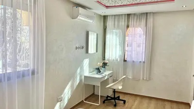 a room with a desk with a chair and a window at T1 App moderne 2 chambres, a 10 min du Stade Moulay Abdellah in Temara