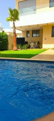 a house with a palm tree in front of a swimming pool at Villa Elia in Tamaris