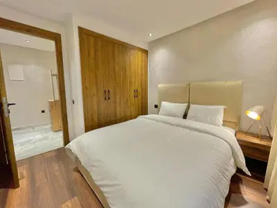 a bedroom with a large white bed and a bathroom at E19 Appt Moderne & Calme à Maarif ,Casablanca in Maarif