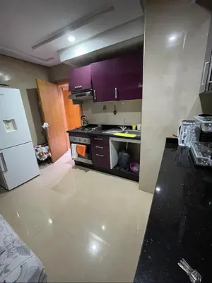 a kitchen with purple cabinets and a white refrigerator at Appartement vue sur mer in Casablanca