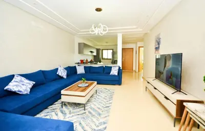 a living room with a blue couch and a table at newly and fully furnished appartment in sidi rahal in Sidi Rahal