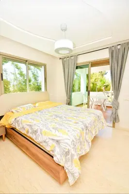a bedroom with a large bed in a room with windows at newly and fully furnished appartment in sidi rahal in Sidi Rahal