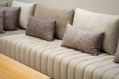 a white couch with several pillows on it at Appartement Élégant et Spacieux in LʼOasis