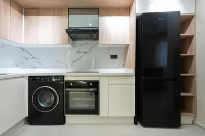 a kitchen with a black refrigerator and a dishwasher at Appartement Élégant et Spacieux in LʼOasis