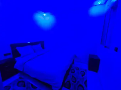 a blue room with a bed with a blue light at Bel appartement à bouznika in Bouznika