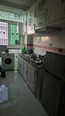 a kitchen with a stove and a sink and a refrigerator at Bel appartement à bouznika in Bouznika