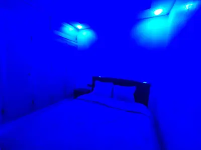 a bedroom with a bed with blue lights on it at Bel appartement à bouznika in Bouznika