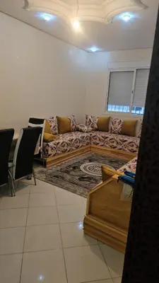 a living room with a couch and a table at Bel appartement à bouznika in Bouznika