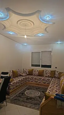 a large couch in a living room with a ceiling at Bel appartement à bouznika in Bouznika