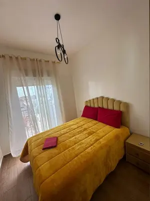 a bedroom with a large yellow bed with red pillows at Appartement Casablanca proche de la mer in Dar Mouddene