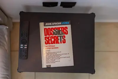 a book hanging on a wall with a remote control at Appartement Moderne au Cœur de Rabat by MERAT HOME in Océan
