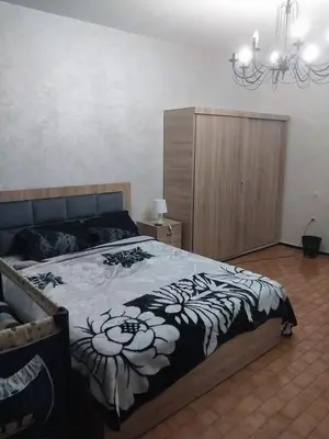 a bedroom with a bed with a black and white blanket at Assabah apartement in Kouas