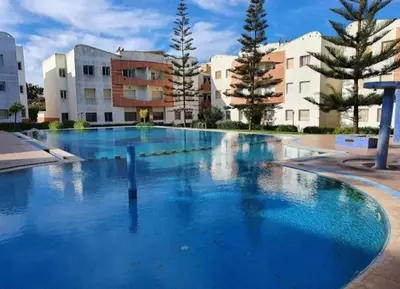 an empty swimming pool with buildings in the background at superbe appartement Al Mansouria-les jardins de l'Atlantique in Pont Blondin