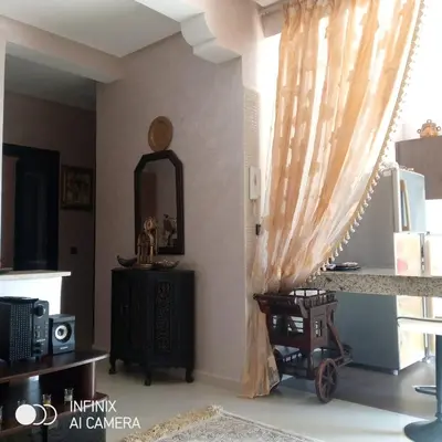 a living room with a curtain and a table at superbe appartement Al Mansouria-les jardins de l'Atlantique in Pont Blondin