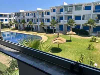 a view of the pool from the balcony of a building at Très bel Appartement avec Piscine et Jardin in Mansouria