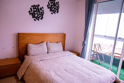 a bedroom with a bed and a large window at Beautiful and Stylish 2BR Appartment with a wide Beach View in Mohammedia