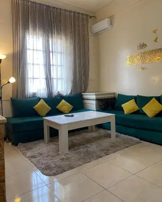 a living room with a green couch and a table at Magnifique Studio Gare - Tram in Les Camps