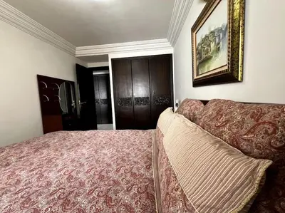 a bedroom with a bed and a couch in it at Appartement moderne en plein centre de l'Agdal in Rabat