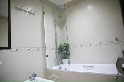 a bathroom with a tub and a sink and a mirror at Appartement moderne en plein centre de l'Agdal in Rabat