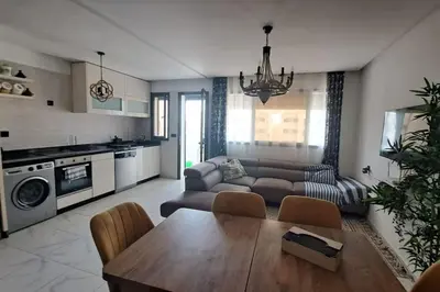 a living room with a couch and a table at Appart familial près de la plage Val d'or in El Harhoura