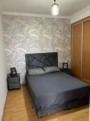 a bedroom with a bed and two night stands at Appartement Oasis beach in Pont Blondin