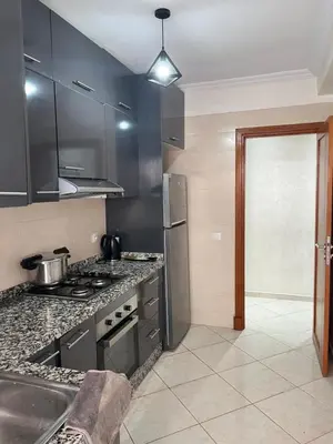 a kitchen with black cabinets and a counter top at Appartement Oasis beach in Pont Blondin