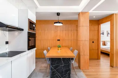 a kitchen with a wooden table and a dining room at Modern and Luxurious apartment in Rabat